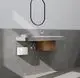 Stiebel Eltron Mini-Durchlauferhitzer, in weiß, montiert unter einem modernen Waschbecken, verbunden mit Wasserrohren, im minimalistischen Badambiente.